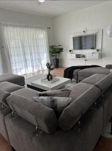 AlbionEagles Nest Villa House AC TV WIFI Fan Luxury Modern的带沙发和电视的客厅