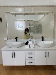 AlbionEagles Nest Villa House AC TV WIFI Fan Luxury Modern的一间带两个盥洗盆和大镜子的浴室