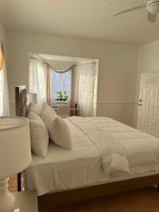 AlbionEagles Nest Villa House AC TV WIFI Fan Luxury Modern的卧室内的白色床和白色枕头