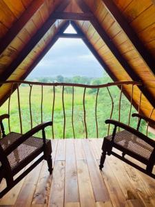 锡吉里亚Prana Ayurveda Chalet- Sigiriya的木甲板上设有2张长椅,享有田野美景