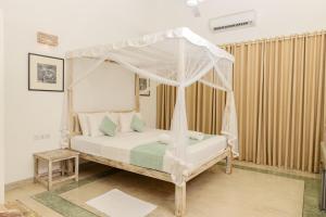 乌纳瓦图纳奥洛拉住宿加早餐旅馆的一间卧室配有一张带天蓬的床