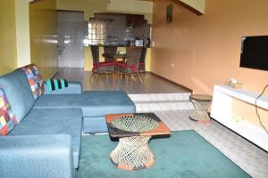 Ongata Rongai 3-bedroom, 2-bedroom, 1-bedroom serenity homes的客厅配有蓝色的沙发和桌子