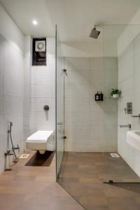 伯杰默里Pandav Inn的一间带卫生间和玻璃淋浴间的浴室