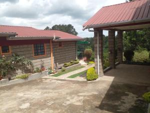 Ongata Rongai 3-bedroom, 2-bedroom, 1-bedroom serenity homes的一座带红色屋顶和庭院的房子