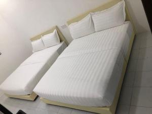怡保SKYN SMART HOME的配有2张床的带白色床单和枕头的客房