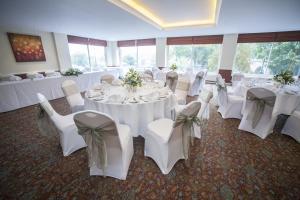 瓦灵福德西陵福特桥酒店的宴会厅配有白色的桌椅和鲜花
