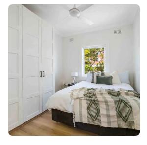 悉尼Little Manly Getaway的白色的卧室设有床和窗户