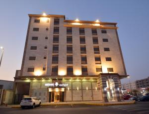 麦地那فندق المرزم-Al Marzam Hotel的前面有停车位的建筑