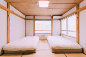 关市Yuzawa Onsen Lodge 1min to LIFT A House的带2扇窗户的客房内的2张床