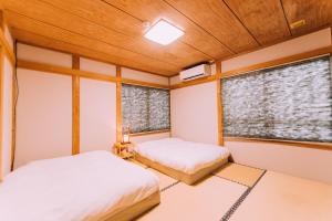 关市Yuzawa Onsen Lodge 1min to LIFT A House的带2扇窗户的客房内的2张床