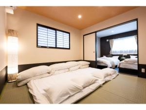 别府BEPPU NO YU TSUKI - Vacation STAY 87965的卧室配有白色的床和窗户。