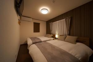 由布市Takanoya Hoshi - Vacation STAY 91923的卧室配有两张床,墙上有灯