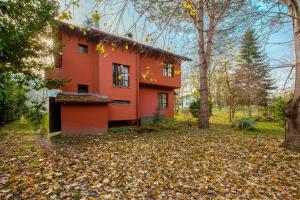 伊兹密特Dreamy Duplex Villa with Huge Garden in Kocaeli的树林里的一个红色房子,地上有树叶