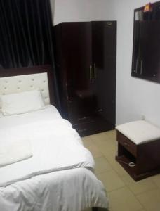 阿奴古Dovan Lodge Enugu的卧室配有白色的床、桌子和窗户。