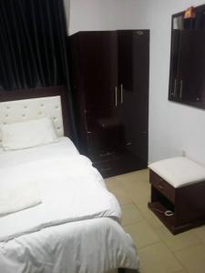 阿奴古Dovan Lodge Enugu的卧室配有白色的床和桌子