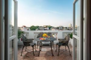 河内Beryl Charm Hotel and Spa的设有一个配有桌椅并享有美景的阳台。