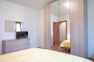 西尼加利亚SE035 - Senigallia, nuovissimo bilocale con ogni comfort的一间卧室配有一张床、一台电视和一面镜子