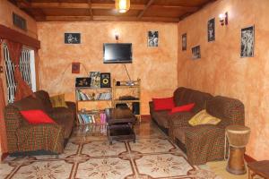 鲁亨盖里Amahoro Guest House的客厅配有两张沙发和一台电视