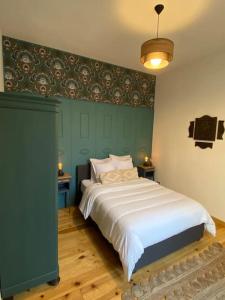 图卢兹Cocon cosy dans la ville rose的一间卧室设有一张大床和绿色的墙壁