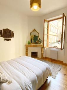 图卢兹Cocon cosy dans la ville rose的卧室配有白色的床和窗户。