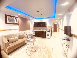 利雅德Al Quba Al Thahbia Hotel Suites 2的带沙发和桌子的客厅以及厨房。