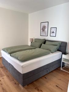 索内纳尔佩·纳斯费尔德Almappartement Nassfeld- Sonnenalpe的一间卧室配有一张带绿色和白色床单的大床