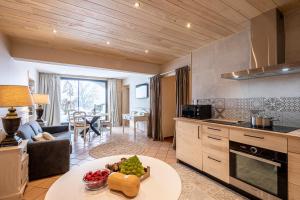 PailherolsLes Maisons de Montagne - Chez Marie的厨房以及带水果桌的客厅。