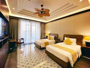 顺化Senna Hue Hotel的酒店客房配有两张床和吊扇。
