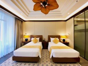 顺化Senna Hue Hotel的酒店客房配有两张床和吊扇。