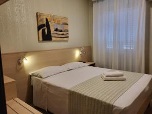 米兰笛费欧里酒店的一间卧室配有一张床,上面有两条毛巾