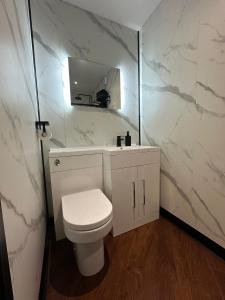 UphollandThe Cottage Hideout的白色的浴室设有卫生间和镜子