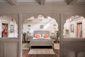 MaheshwarAhilya Fort的一间卧室配有带橙色枕头的床