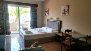 阿德里安诺斯坎波斯Jo An Beach Hotel的一间卧室配有一张床、一张桌子和一个窗户。