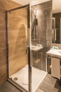 布达厄尔什Holiday Inn Budapest-Budaörs, an IHG Hotel的浴室里设有玻璃门淋浴