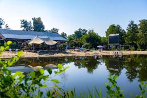 金洛伊Glamping Limburg - Back To Nature Experience的享有湖景,设有建筑和帐篷