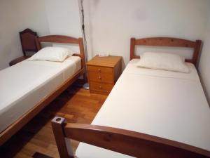 圣克鲁斯Costa Lodge Madeira, pick up - drop off, car and motorcycle rentals的一间卧室设有两张床和床头柜