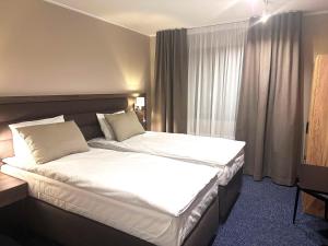 罗瓦涅米Hotel Boreas的酒店客房带一张大床,带白色床单