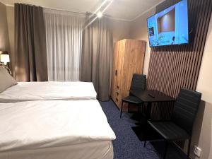 罗瓦涅米Hotel Boreas的酒店客房设有一张床、一张书桌和一台电视机。
