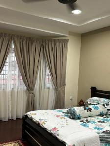 怡保Homestay Hajrah的一间卧室配有一张带窗帘的大床
