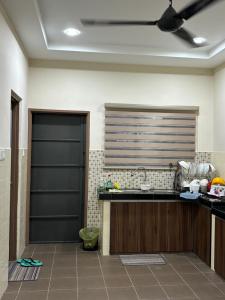 怡保Homestay Hajrah的厨房配有柜台和吊扇。
