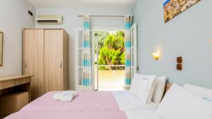 阿齐欧斯·贡多斯Marina Apartments, Agios Gordios Corfu的卧室配有粉色和白色的床和窗户。