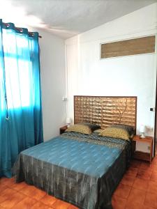 圣安尼Locamarre G GONDET的一间卧室配有一张带蓝色床单和蓝色窗帘的床。