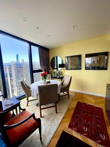 悉尼Sydney Cosmopolitan CBD Apartment的客厅配有桌椅和大窗户