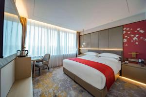 北京北京宝辰饭店Howard Johnson的酒店客房设有一张大床和一张书桌。