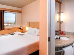 欧里尼奥斯ibis Ourinhos的酒店客房设有床和水槽