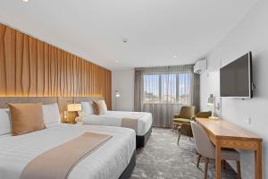 基督城Hotel Elms Christchurch, Ascend Hotel Collection的酒店客房设有两张床和一台平面电视。