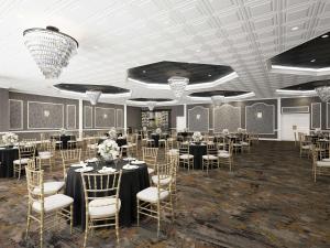 波基普西DoubleTree by Hilton Poughkeepsie的宴会厅配有桌椅和吊灯