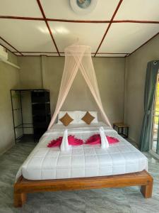 俊穆岛Happy Home Kohjum的一间卧室配有一张带天蓬的白色床