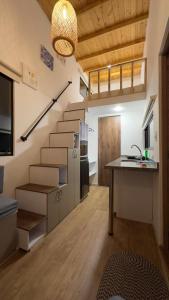 派帕Corinto Tiny House的带楼梯的客房和带桌子的厨房