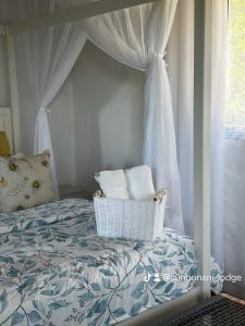 马普托Sunbonani Lodge的卧室配有带白色窗帘的天蓬床